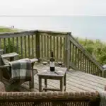 Two Muskoka chairs and wine on a cottage deck overlooking Lake Huron, a couples getaway Grand Bend setting